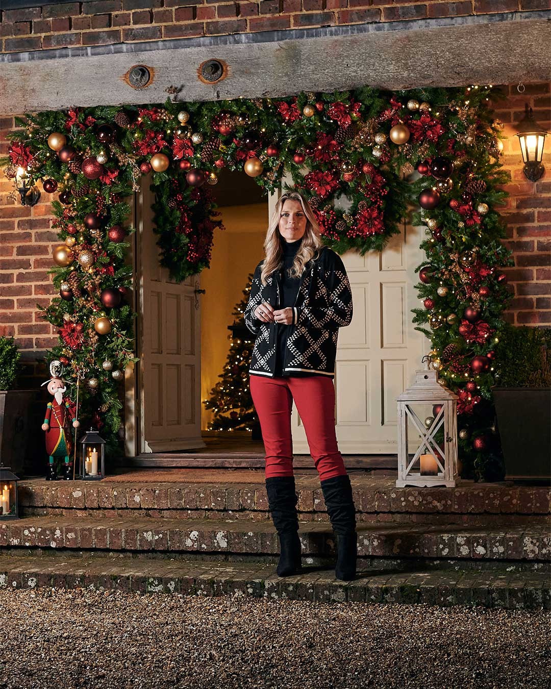 Winter red fleece lined trousers and black geometric hoodie outside a christmas decorated door entrance