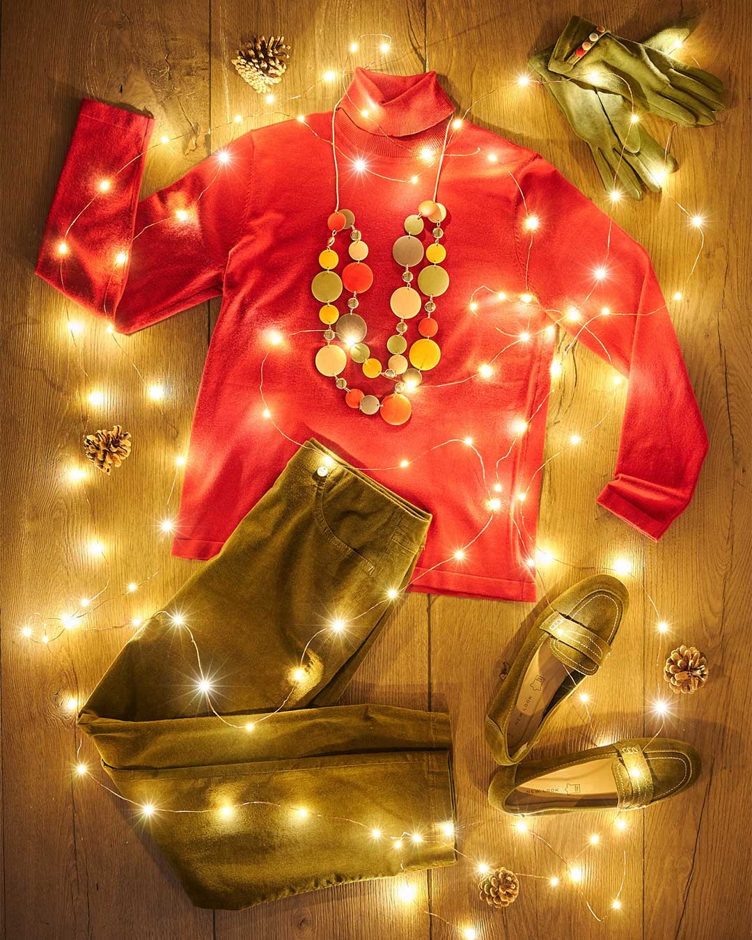 Green and red christmas outfit flat lay with robell needlecord trousers and red jumper